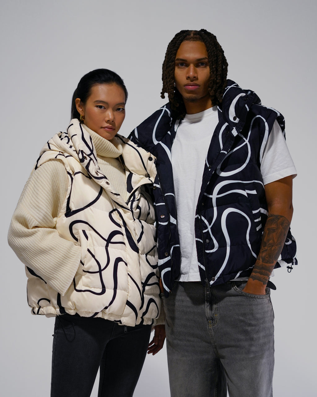 Two people wearing patterned puffer vests 