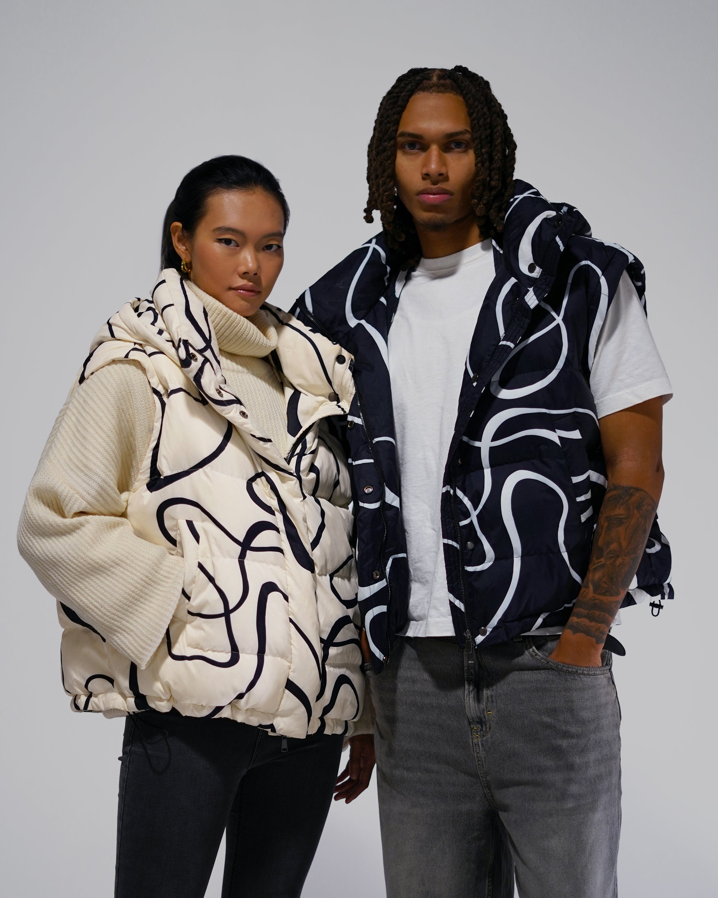 Two people wearing patterned puffer vests 