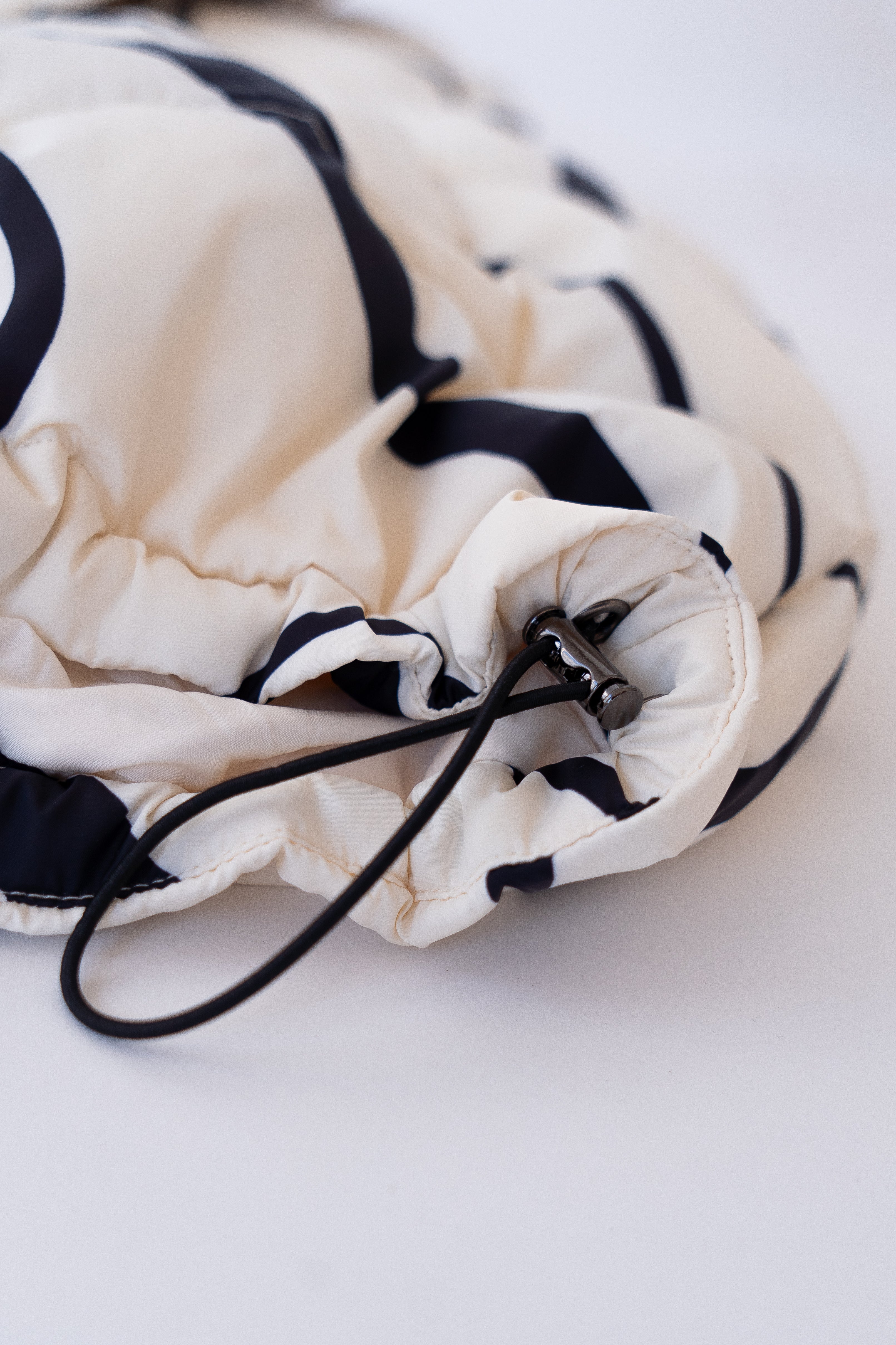 Drawstring jacket with black and white pattern on a white background